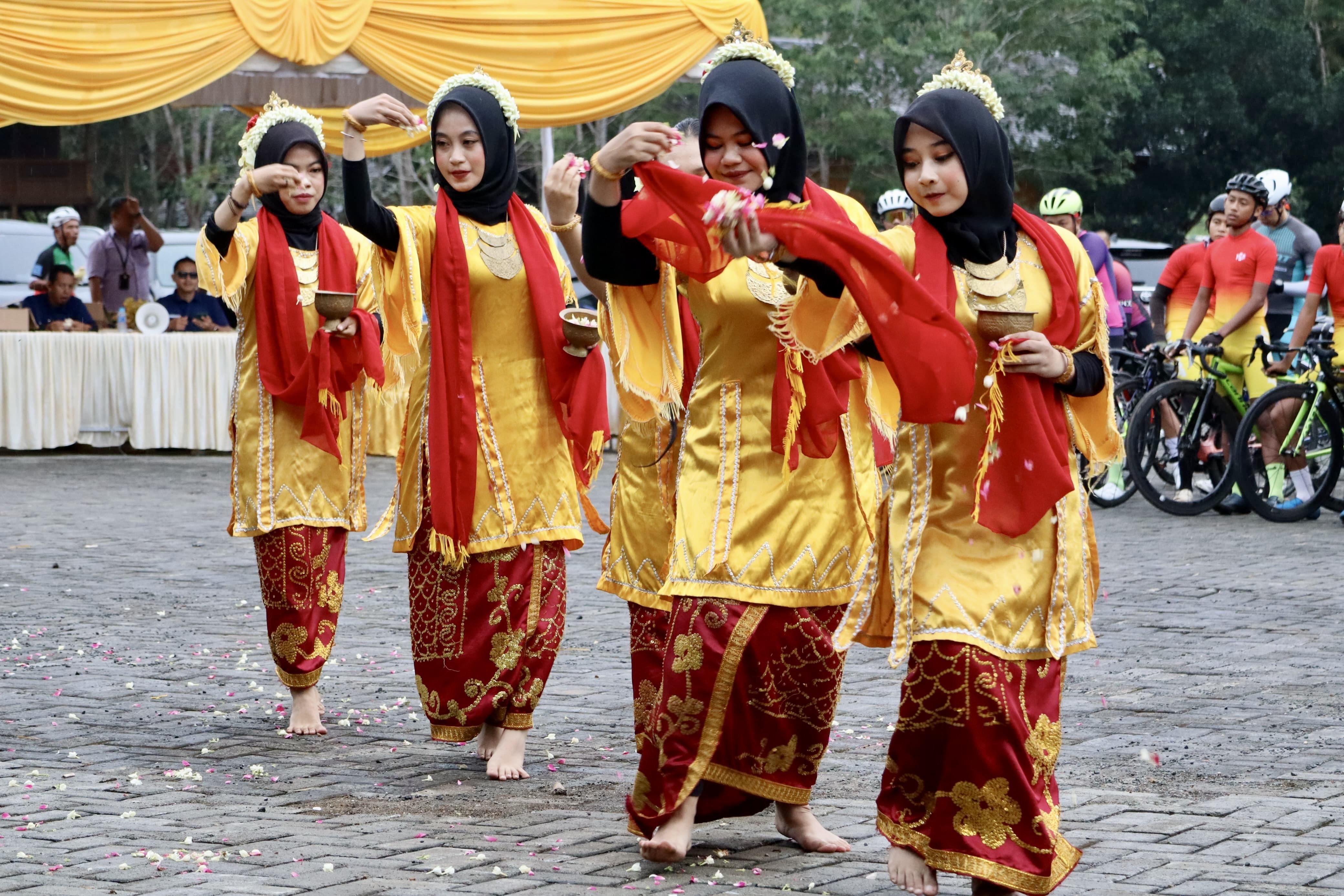 Foto resmi pemerintah menunjukkan sejumlah penari membawakan Radap Rahayu pada pembukaan Tour de Loksado di Kiram Park, Kabupaten Banjar. Para penari menggunakan busana kuning-merah dan membawa wadah kecil dalam gerakan tari. Dokumentasi ini diterbitkan InfoPublik pada 1 Juli 2024 dan mencantumkan fotografer Jamil dari Media Center Provinsi Kalimantan Selatan.