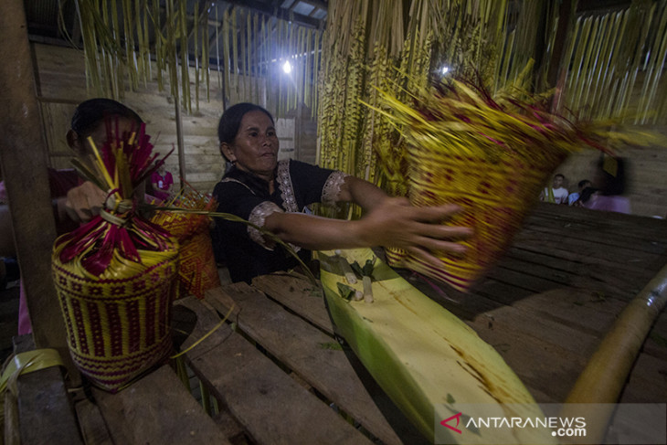 Masyarakat menyiapkan sesajian dan mengikuti ritual di Balai Adat Dusun Bayawana. Foto tersebut juga menunjukkan peran balian dalam memimpin doa serta penggunaan beras dan perlengkapan ritual.