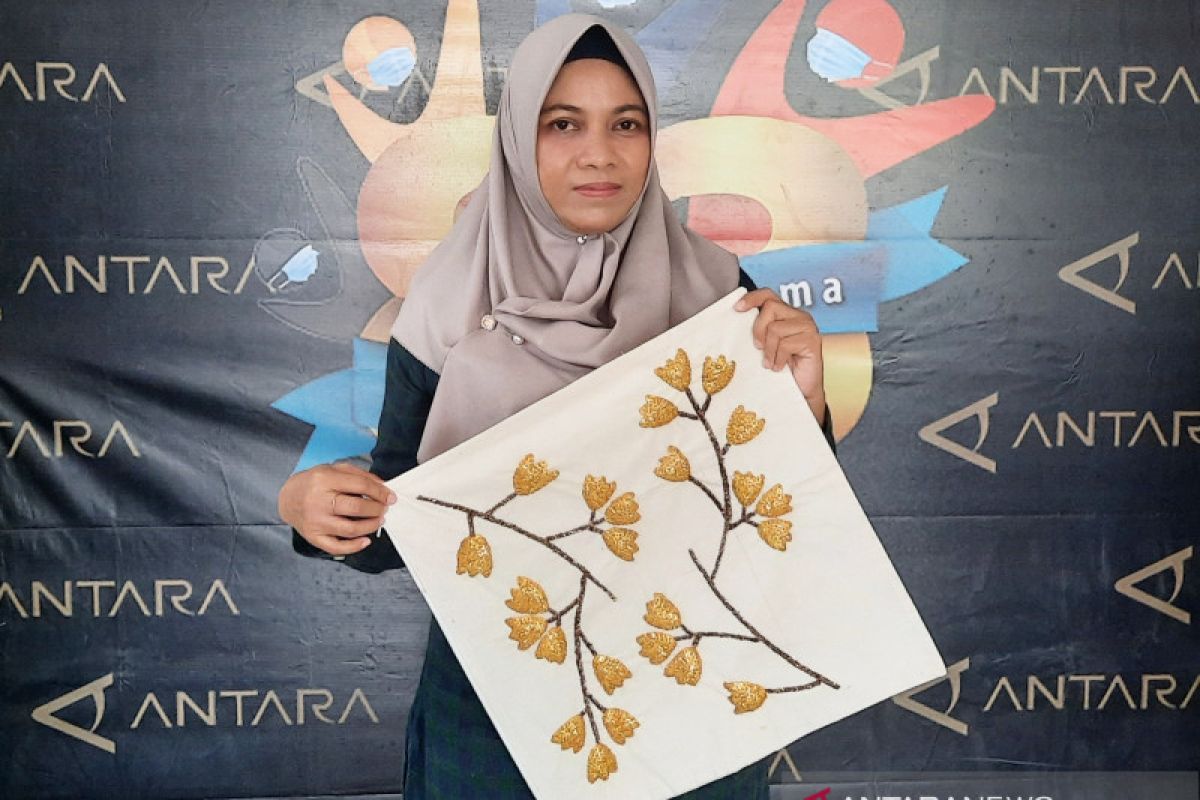 Risna Apriliyana (Iin), perajin generasi ketiga Air Guci Banjar di Argadia Melati, Kota Banjarmasin. Beliau meneruskan usaha keluarga yang telah berkembang sejak sekitar tahun 1960-an dan aktif melestarikan teknik sulam Air Guci secara tradisional. Selain memproduksi perlengkapan adat Banjar, Iin juga mengembangkan berbagai produk kreatif seperti tas, dompet, hiasan dinding, busana, dan aksesori agar Air Guci tetap diminati oleh masyarakat modern